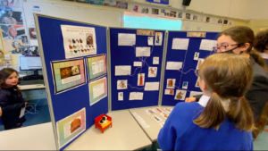 Senior girls explain their display boards to Junior girls